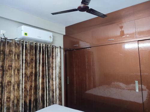 a ceiling fan in a room with a sliding glass door at Rahul's Castle Guest House in Visakhapatnam