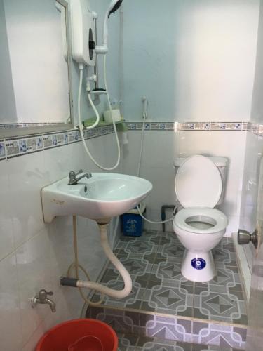 a bathroom with a toilet and a sink at Khách sạn Thiên Phúc in Cà Mau