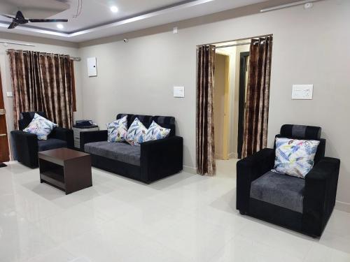 a living room with two chairs and a table and a mirror at Rahul's Castle Guest House in Visakhapatnam