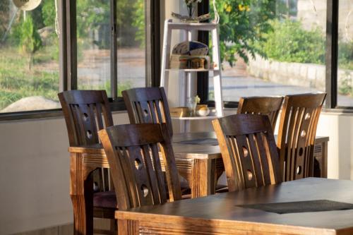 a table and chairs in a kitchen with a window at Dhauladhar View Village Resort in Dharmsāla