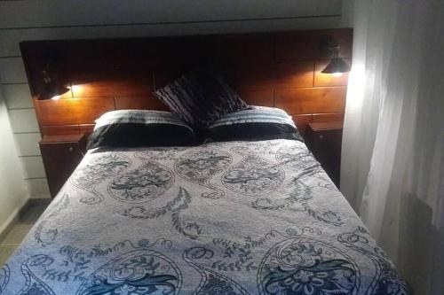uma cama com um edredão azul e branco em Cozy Townhouse & Terrace/Pool em La Ceiba