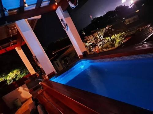 a swimming pool at night with the lights on at Cozy Townhouse & Terrace/Pool in La Ceiba