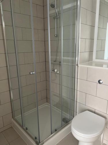 une douche avec une porte en verre à côté des toilettes dans l'établissement Salford Manchester, à Manchester