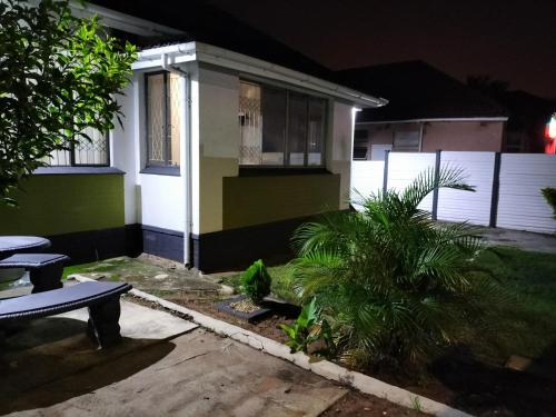 a house with green and white paint at night at Inkanyezi guest house in Durban