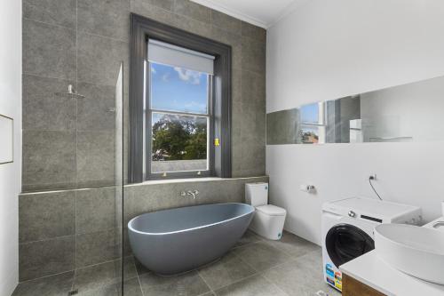 a bathroom with a tub and a toilet and a sink at Costello Hotels Port Augusta in Port Augusta