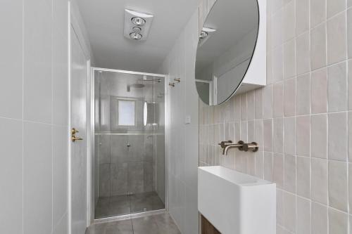 a bathroom with a shower and a sink and a mirror at Costello Hotels Port Augusta in Port Augusta