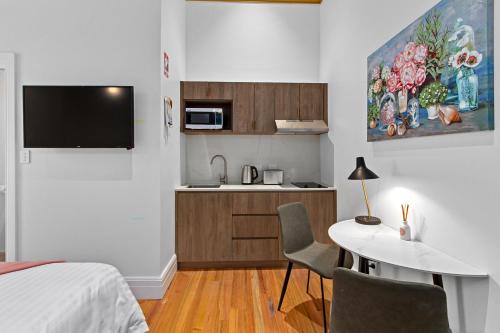 a room with a bed and a table and a kitchen at Costello Hotels Port Augusta in Port Augusta