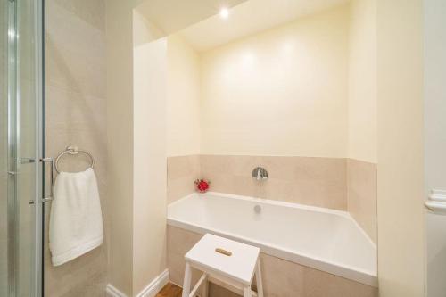 a white bathroom with a tub and a shower at Dreamy Town House Apartment in Birnam, Dunkeld in Birnam