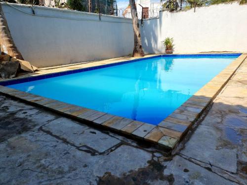 a swimming pool with blue water and a wooden path at Lux Suites Solar Holiday Apartments in Shanzu
