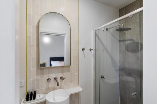 a bathroom with a shower and a sink and a mirror at Costello Hotels Port Augusta in Port Augusta