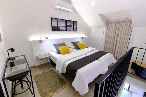 1 dormitorio con 1 cama grande con almohadas amarillas en Home2Book Modern Design Seaview Apt, Pool&Terrace en Playa de las Américas