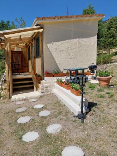 a house with a grill in front of it at Petit studio dans la prairie in Saint-Auban