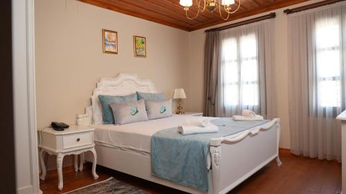 a bedroom with a large white bed with blue pillows at Domatia Stone Hotel in Soke