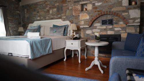 a bedroom with a bed and a stone wall at Domatia Stone Hotel in Soke