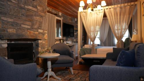 a living room with a fireplace and a bedroom at Domatia Stone Hotel in Soke