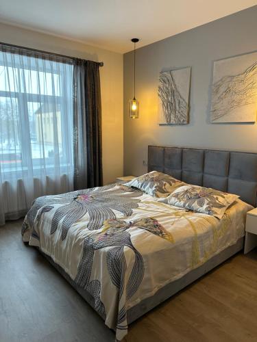 a bedroom with a large bed with a large window at AN apartment 2 in Rēzekne
