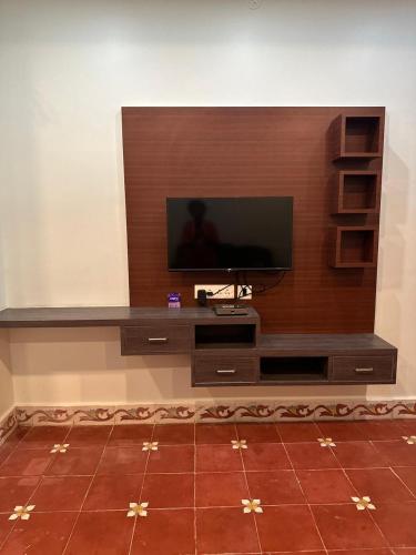 a entertainment center with a flat screen tv on a wall at Serene Villa in Puducherry