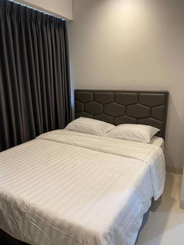 a bedroom with a large bed with white sheets at Luxe 1-Bedroom Haven with Ocean View on the 5th Floor of Kalani Tower in Nongsa