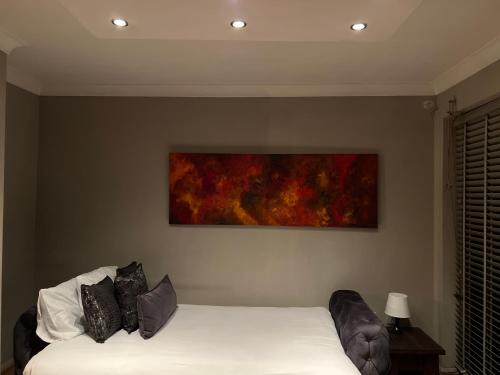a bedroom with a bed and a painting on the wall at Twilight in London
