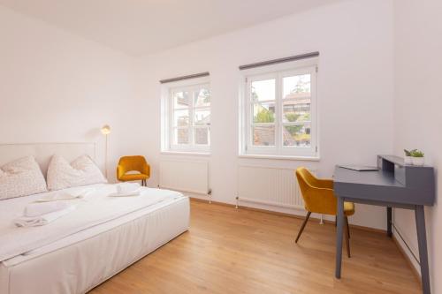 シュタイアーにあるSiebensternehausのベッドと机のある白い寝室