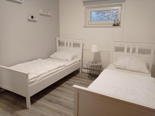 Duas camas brancas num quarto com uma janela em Appartement 2 Schlafzimmer, Terrasse, Hund, Kamin em Bodenwerder