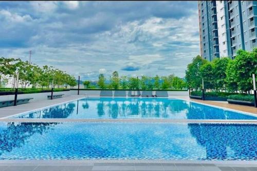 uma piscina com água azul num edifício em MamaQarl Homestay@KLIA&PICC+ Wi-Fi+Neflix 7pax em Sepang