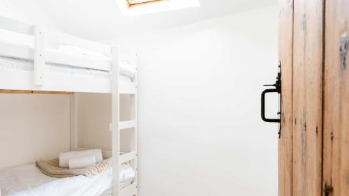 ein Schlafzimmer mit Etagenbetten in einem weißen Zimmer in der Unterkunft Rose Cottage in Buxton