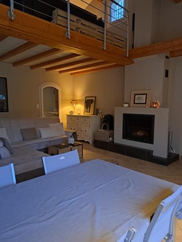 a living room with a table and a fireplace at Chambre privé entre Lyon et St Etienne in Rive-de-Gier