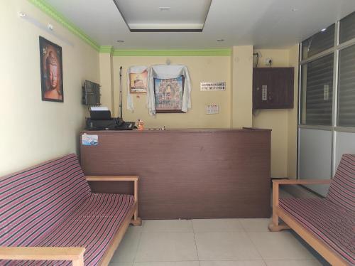 una sala d'attesa con due panche e un bancone di Hotel Tayatha a Tawang
