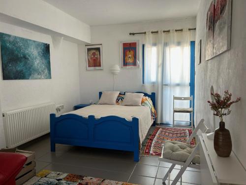 ein Schlafzimmer mit einem blauen Bett und einem Stuhl in der Unterkunft Endless Sunset in Pendakomo