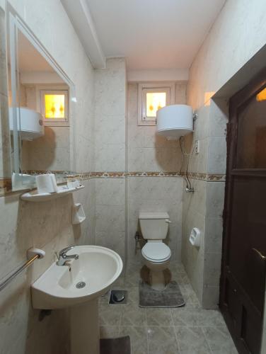a bathroom with a white toilet and a sink at Crystal pyramid inn in Cairo
