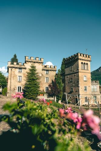 un viejo castillo con flores delante en Villa Pruner, en Cognola