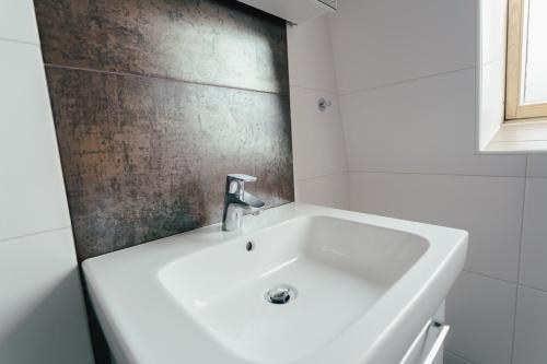 a white bath tub with a sink in a bathroom at Stadtapartment KUS in Klagenfurt