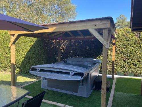 a barbecue grill under a wooden pergola at Swallow lodge in Lincolnshire