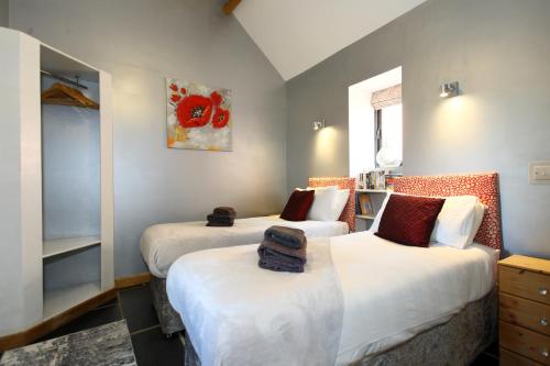 ein Schlafzimmer mit 2 Betten und einem Wandgemälde in der Unterkunft Woodshed Cottage in Ashbourne
