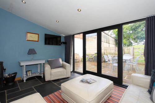 a living room with a couch and chairs and a table at Woodshed Cottage in Ashbourne