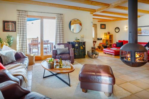 a living room with a fire place in the middle at Chalet la Croix Meridionale - OVO Network in Manigod