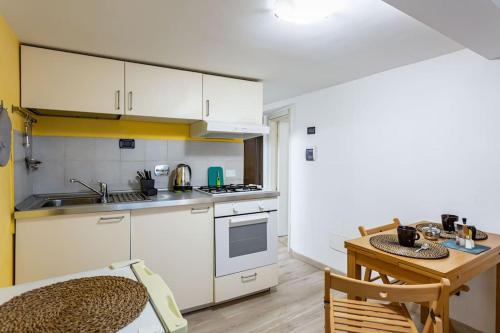 uma cozinha com armários brancos e uma mesa de madeira em Apartment Adorno 2 - Affitti Brevi Italia em Gênova