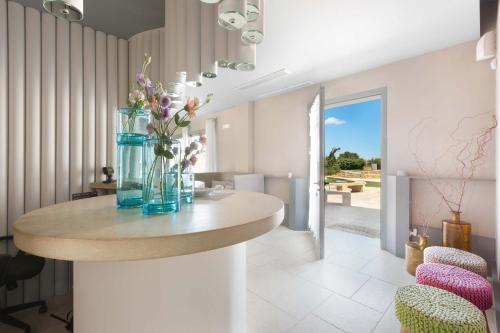 a vase of flowers on a table in a room at Masseria Sant'Eleuterio in Collepasso