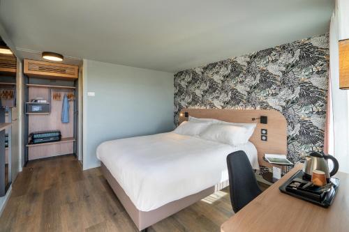 una camera d'albergo con letto, scrivania e tavolo di Sure Hotel by Best Western Rochefort-sur-Mer a Tonnay-Charente