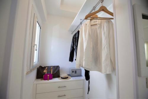 a white room with a dresser and a window at Hotel Elite in Cervia