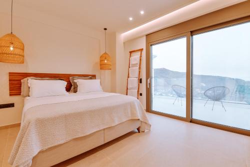 a bedroom with a bed and a large window at MiLiON RESIDENCES in Parga
