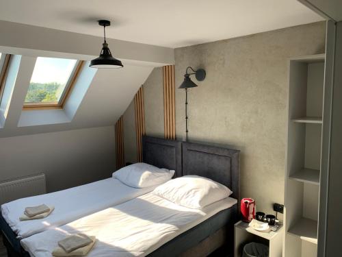 a bedroom with a bed with white sheets and a window at Guest Apartments Orłowo in Gdynia