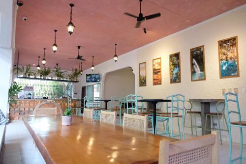 une salle à manger avec une grande table et des chaises en bois dans l'établissement Mad Monkey Dumaguete, à Dumaguete