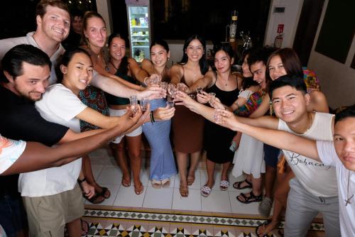 a group of people holding up wine glasses at a party at Mad Monkey Dumaguete in Dumaguete