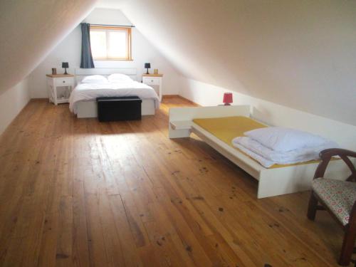 a attic bedroom with two beds and a window at Cottage Lillstugan proche de la Baie de Somme in Quesnoy-le-Montant