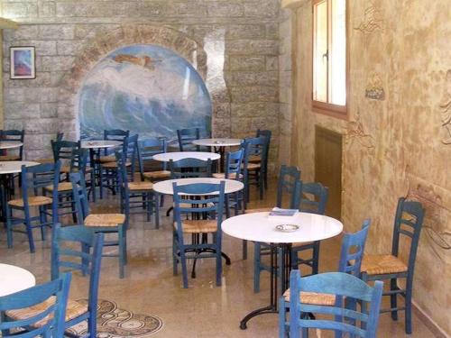 a dining room with tables and blue chairs at Hotel Korakakis Beach in Finikounta