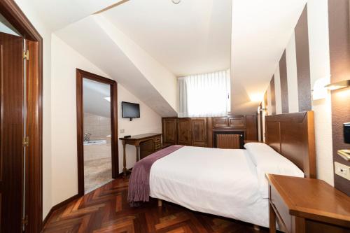 a hotel room with a bed and a mirror at Hotel Restaurante De Torres in Felechosa