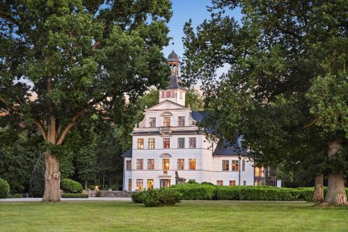 a large white house with a tower on top of it at GUT KLETKAMP "Penthouse im Schloss" - Premium-Ferienwohnung mit 5 Schlafzimmern auf 400qm I Kamin I 2 Wohnzimmer I Garten & Terrasse I Wald- und Seeblick I Profi-Küche I 15 Min zur Ostsee I Parkplätze I WLAN in Kletkamp
