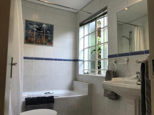 ein Badezimmer mit einer Badewanne, einem Waschbecken und einem WC in der Unterkunft Darrenwood Guesthouse & SPA in Johannesburg